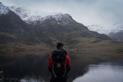 Rear view of man on lake against mountains
