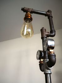 Close-up of light bulb against wall