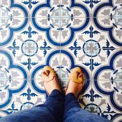 Low section of woman standing on tiled floor