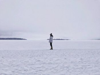 Man standing in sea against clear sky