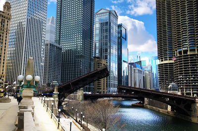 Bridge over canal amidst buildings in city against sky