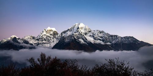 Scenic view of snowcapped mountains against clear sky