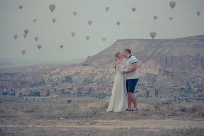 Rear view of man and woman with arms raised