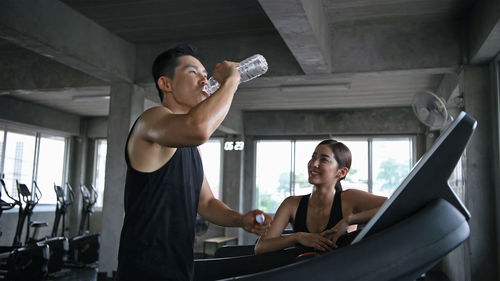 Instructor and woman talking at gym