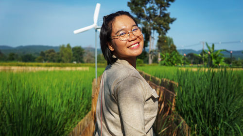 Portrait of smiling young woman wearing sunglasses on land