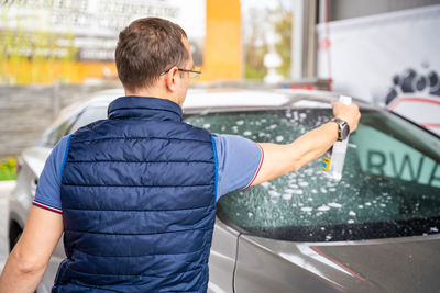 Rear view of man standing in car