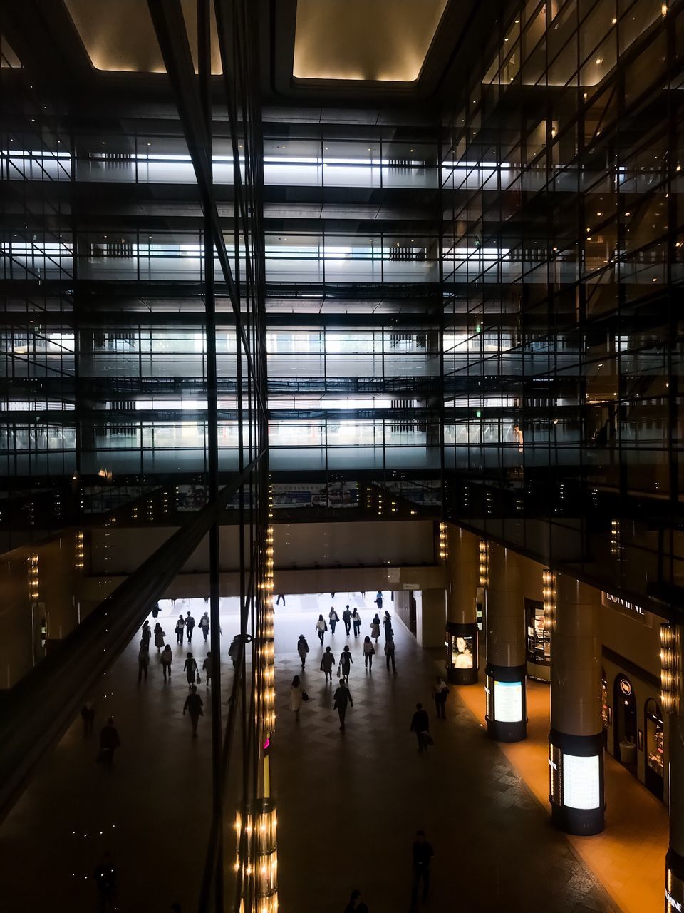 architecture, reflection, built structure, illuminated, indoors, real people, night, building, group of people, city, modern, glass - material, travel, incidental people, men, lifestyles, travel destinations, ceiling, water, flooring, light