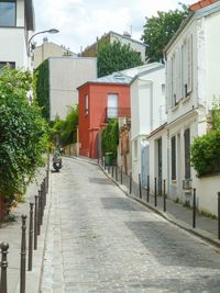 Footpath amidst buildings in city