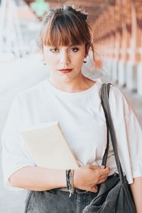 Portrait of young woman standing against wall