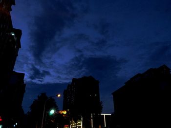 Low angle view of illuminated buildings against sky at night