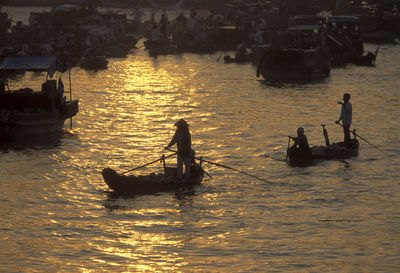 High angle view of fishermen fishing in river during sunset
