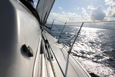 Close-up of sailboat sailing on sea against sky