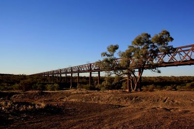 Built structure on field against clear blue sky