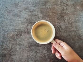 Directly above shot of hand holding coffee cup