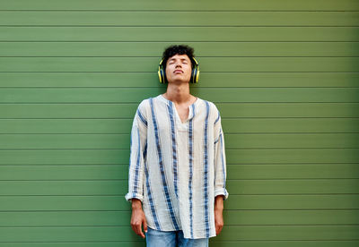 Portrait of mid adult man standing against wall