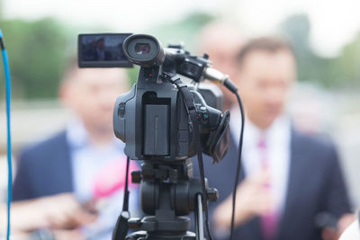 Close-up of television camera with businessman in background