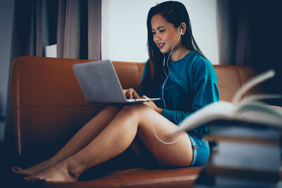 Young woman using mobile phone at home