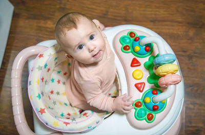 High angle view of cute baby girl standing on table