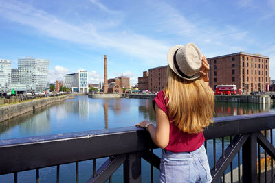 Back view of traveler girl on swing bridge visiting the royal albert dock in liverpool, england.