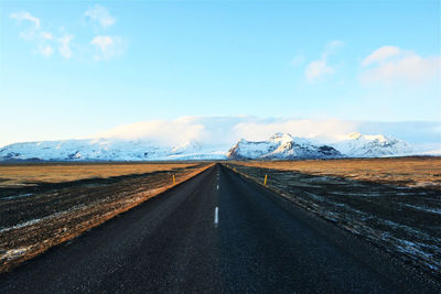 Road passing through landscape against sky