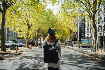 Rear view of woman standing on street in city