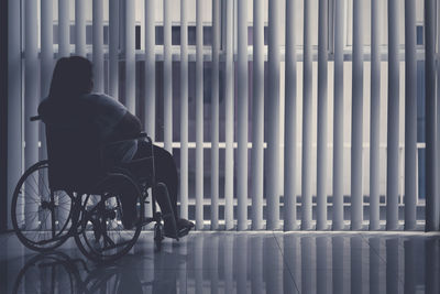 Rear view of man sitting in corridor