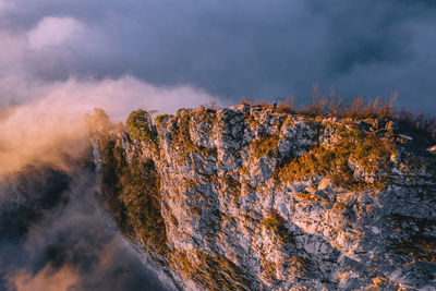 High angle view of man standing on mountain ridge rising above the clouds, hallein, austria