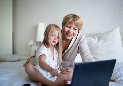 Grandmother and granddaughter looking at laptop