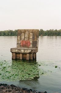Old built structure in lake against clear sky