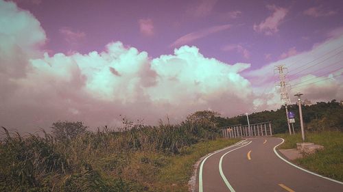 Empty road against cloudy sky