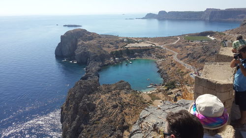 High angle view of people on rock by sea