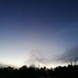 Low angle view of silhouette trees against sky