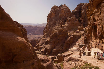 Rear view of man and woman hiking at rocky mountains