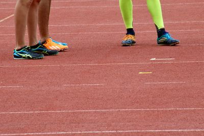 Low section of athletes standing on running track