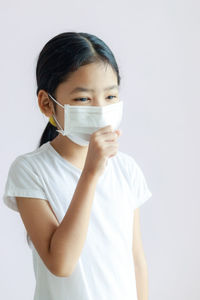 Portrait of girl standing against white background