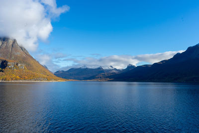 Scenic view of lake by mountains against sky