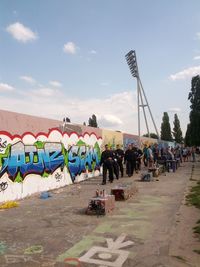 People in park against cloudy sky