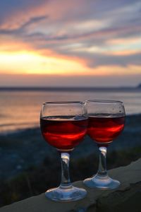 Wineglass against sky during sunset