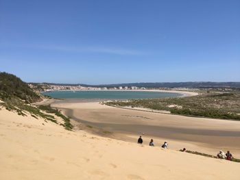 Scenic view of beach against clear blue sky