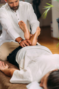 Therapist stretching womans legs. shiatsu massage.