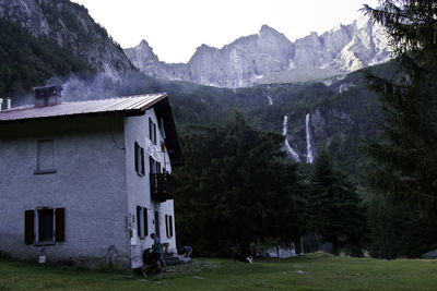 House amidst trees and buildings against sky