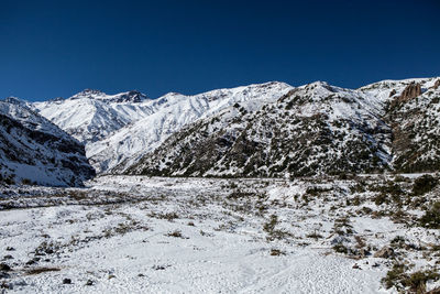 Scenic view of snowcapped mountains against clear blue sky