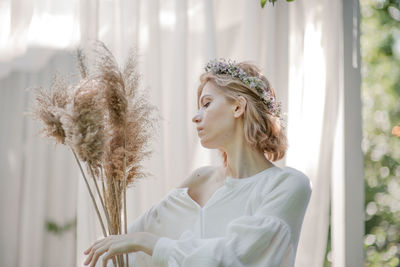 Portrait of young woman looking at plants