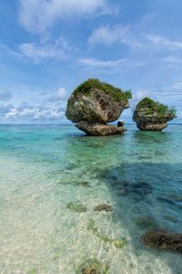 Scenic view of rock formation in sea against sky