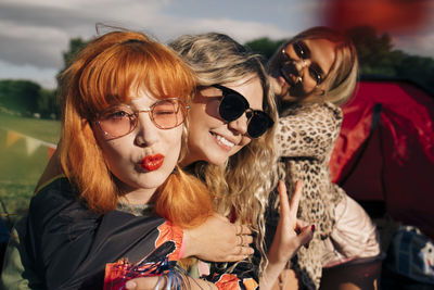 Smiling friends gesturing while enjoying in party at music festival