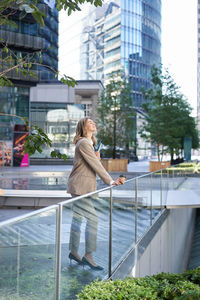 Side view of young woman standing in city