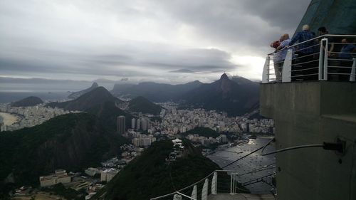 People standing on observation point in city against sky