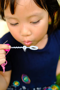 Close-up of girl blowing bubbles