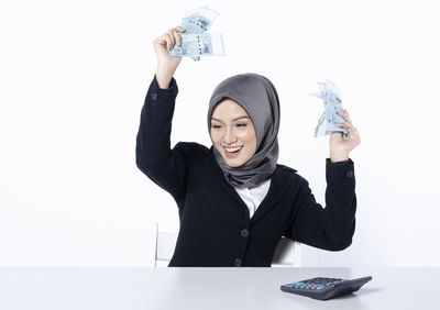 Portrait of a smiling young woman against white background