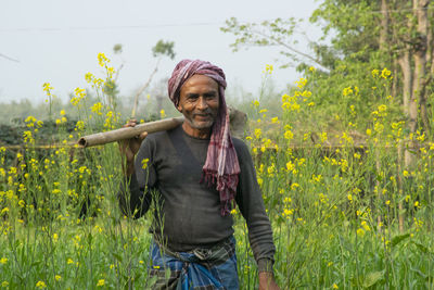 Portrait of smiling young woman standing on field